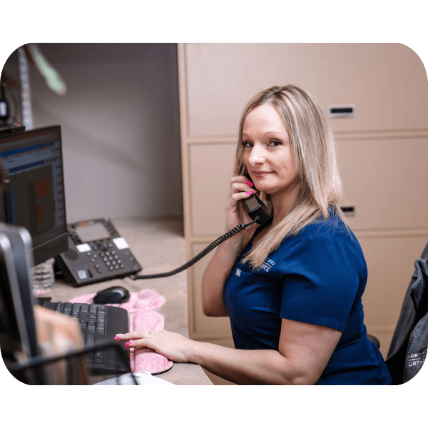 Woman Smiling at desk while at the phone